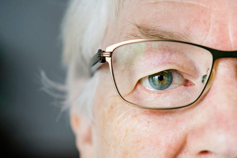 Pola lica umirovljenice koja na očima ima naočale