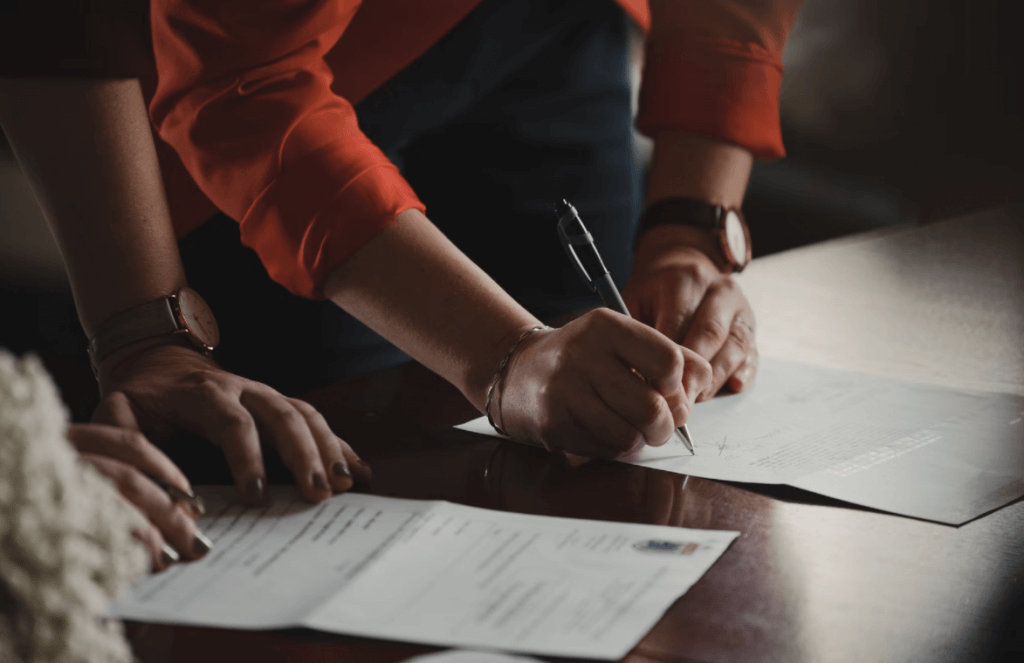 osoba potpisuje papire