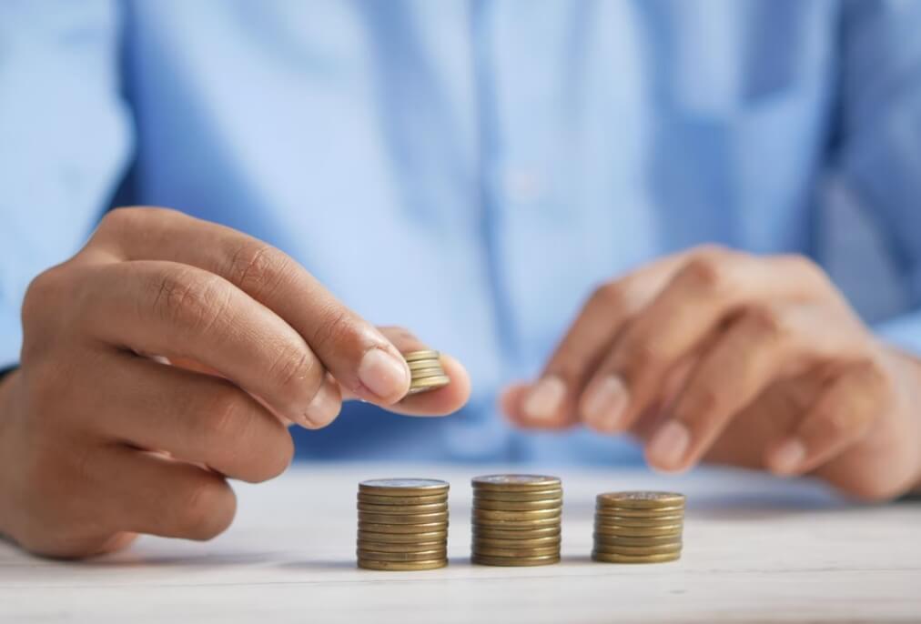 Ruke osobe slažu kovanice na hrpu