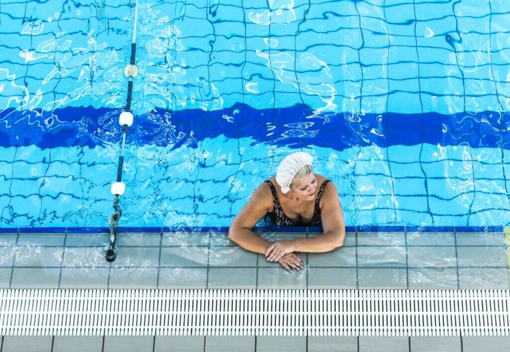 Starija ženska osoba s kapom na glavi u bazenu