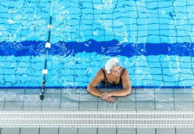 Starija ženska osoba s kapom na glavi u bazenu