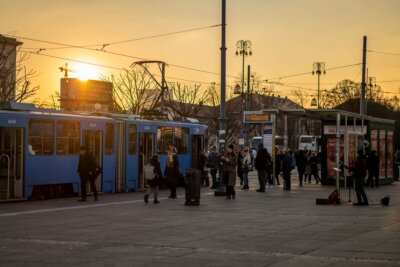 Ljudi čekaju plavi tramvaj na stanici u Zagrebu