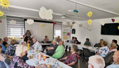 Umirovljenici sjede na stolovima i slušaju predavanje