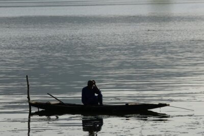 umirovljenik sjedi u čamcu na rijeci ili jezeru