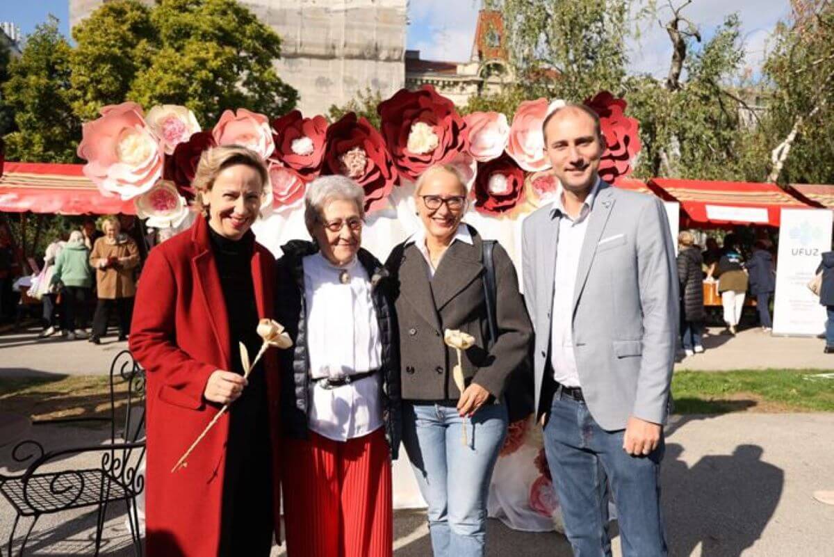 Danijela Dolenec u crvenom kaputu s dvoje umirovljenika na Gerontološkom tulumu