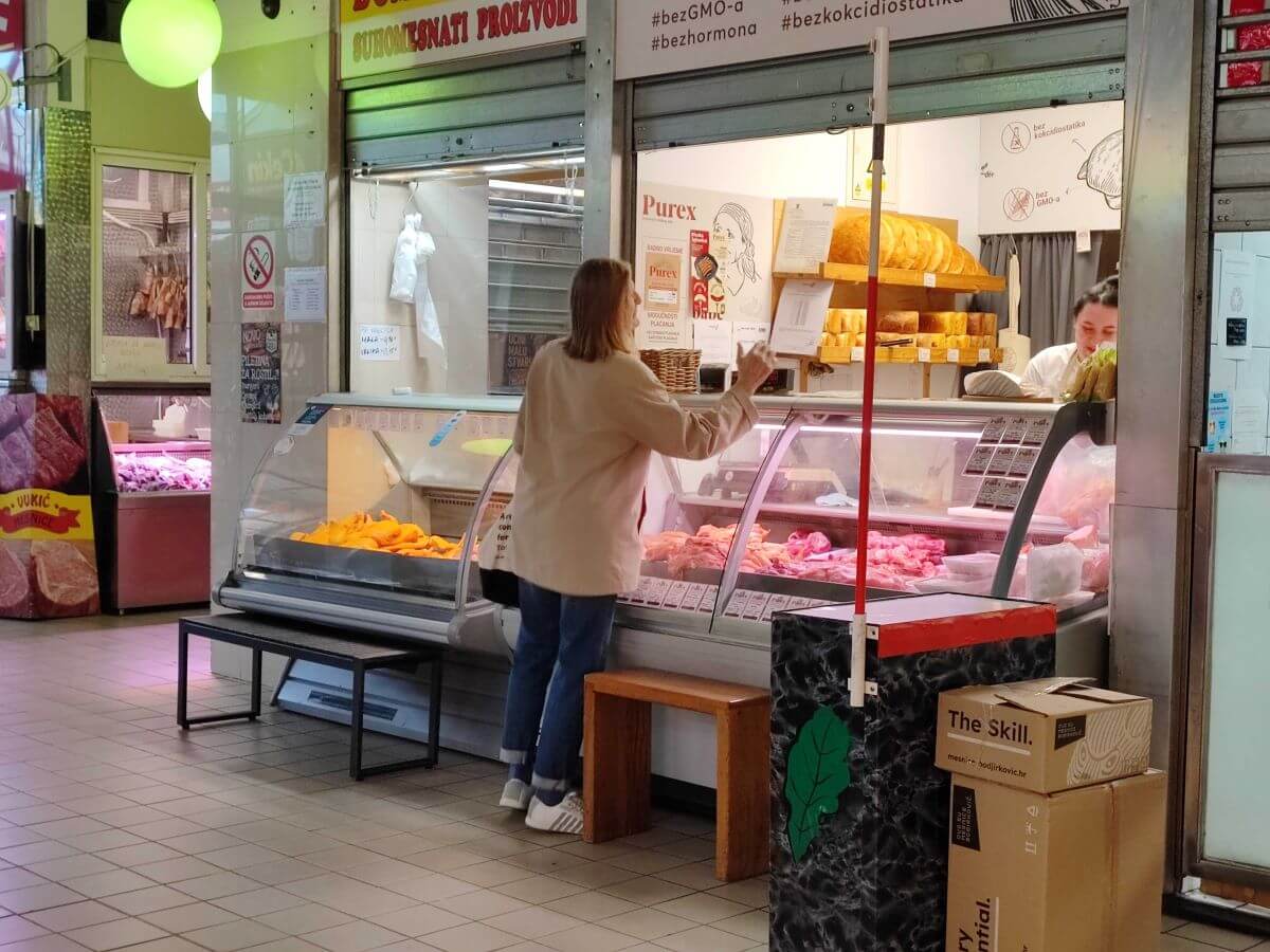 Žena u mesnici kupuje meso