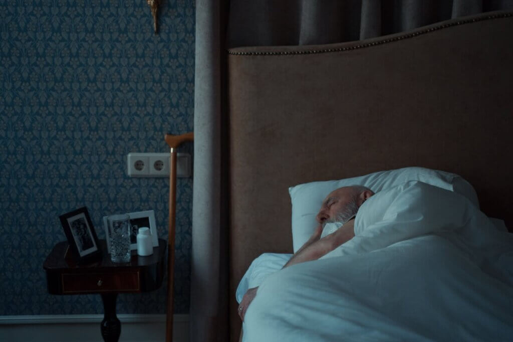 Umirovljenik u krevetu u mraku